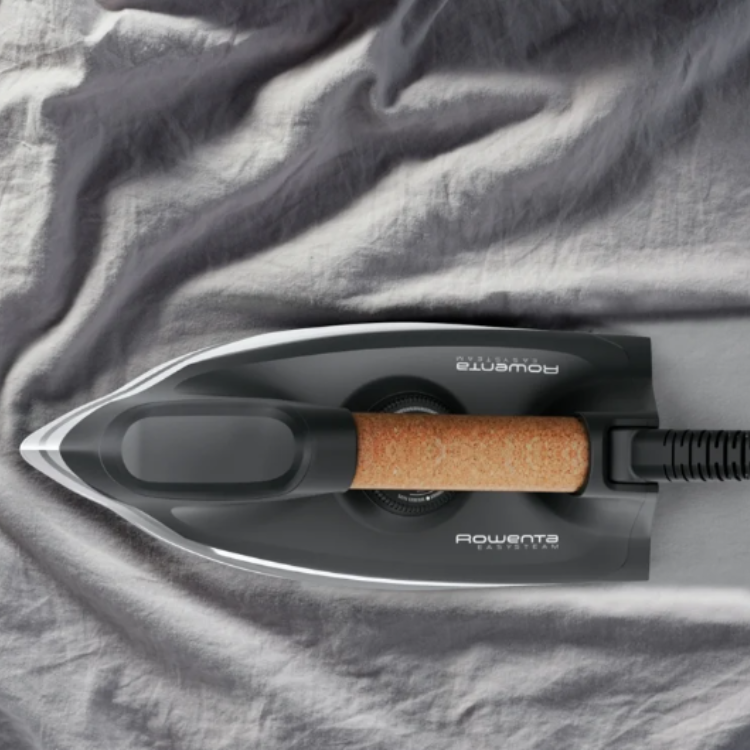 Black Rowenta Easy Steam iron on gray fabric, brown handle.