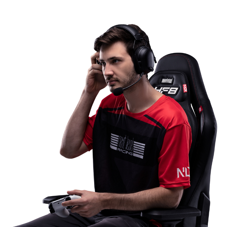 Man sitting on Next Level Racing HF8 gaming chair with headset and controller.