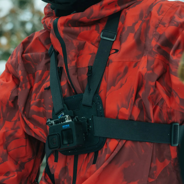 GoPro Chesty chest mount on red camouflage jacket, black straps and camera.