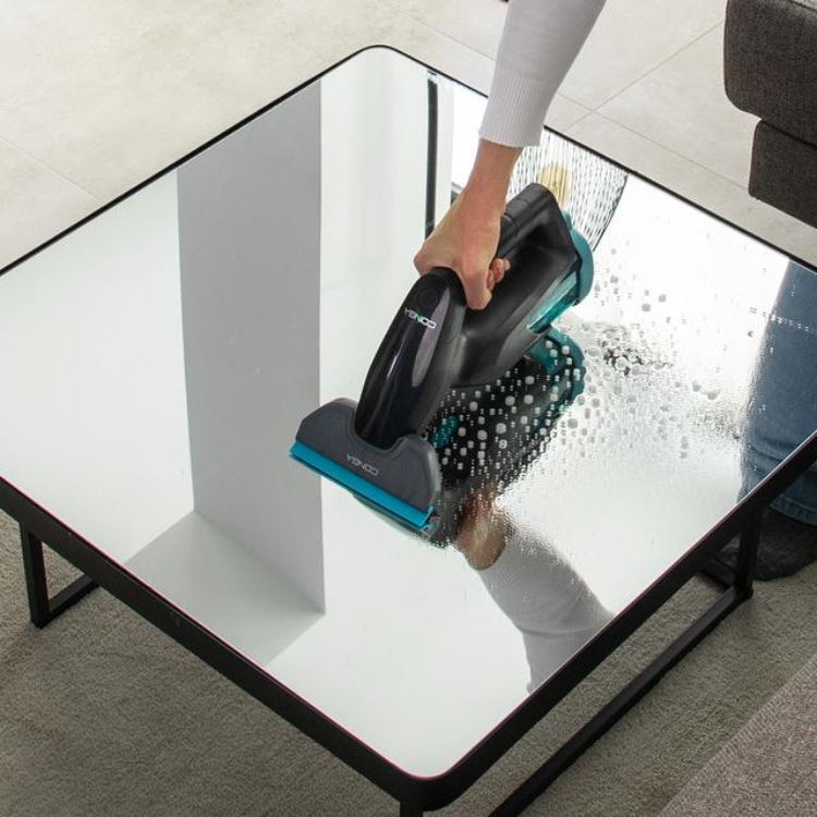 Aspirador de vidros Cecotec Conga Popstar Glass Titânio a limpar mesa de vidro com água.