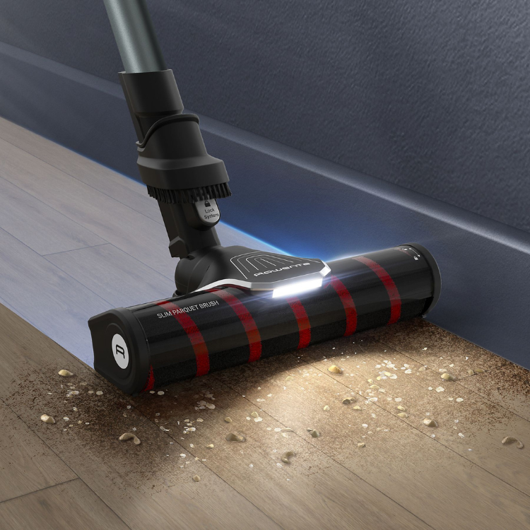Aspirador vertical Rowenta RH2048 X-Force Flex 9.60 preto com faixas vermelhas, limpando piso de madeira com luz LED acesa.