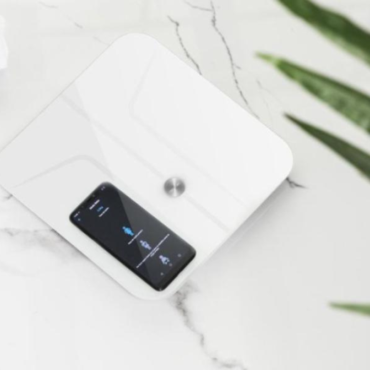 White Cecotec smart scale with black screen on marble surface