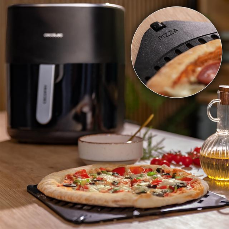 Black Cecotec air fryer with pizza on tray, toppings visible.
