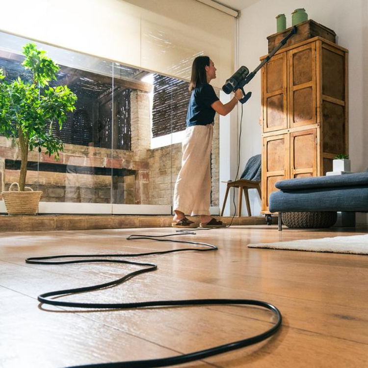 Woman using Cecotec Conga Rockstar 800 vacuum cleaner.