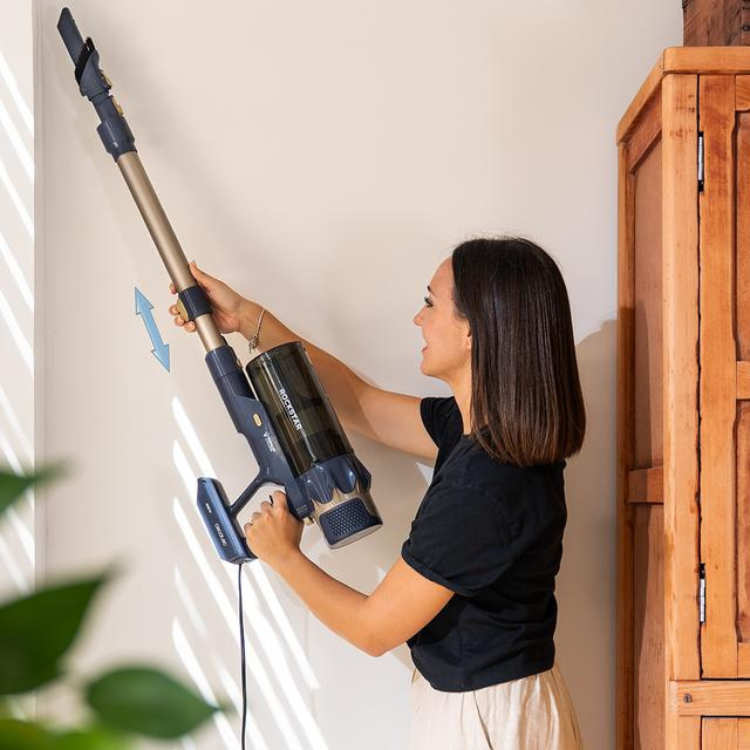 Woman using Cecotec Conga Rockstar 800 vacuum on wall.
