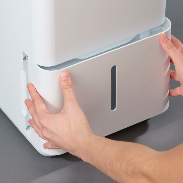 White Jocel dehumidifier, 2L capacity, hands removing water tank.
