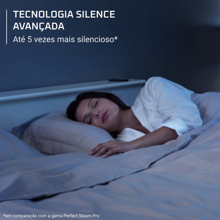 Woman sleeping peacefully on a bed with gray sheets and pillow, wearing white shirt.