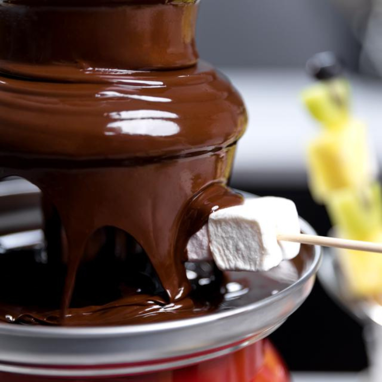 Red Cecotec chocolate fondue fountain with melting chocolate and marshmallow.