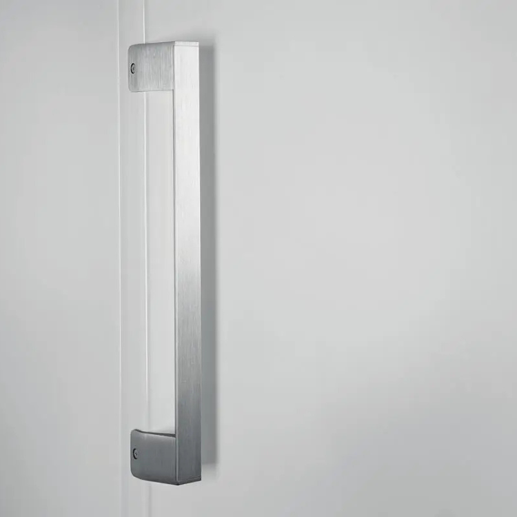 Puxador de porta de frigorífico Whirlpool, metal cromado, fixado em porta branca.