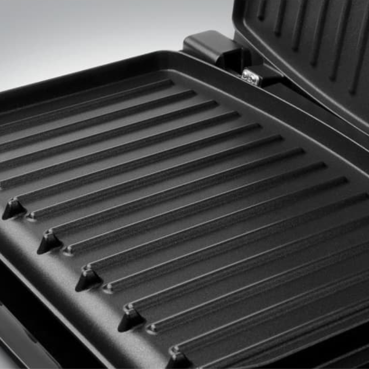 George Foreman grill, black, ribbed cooking surface, open lid.