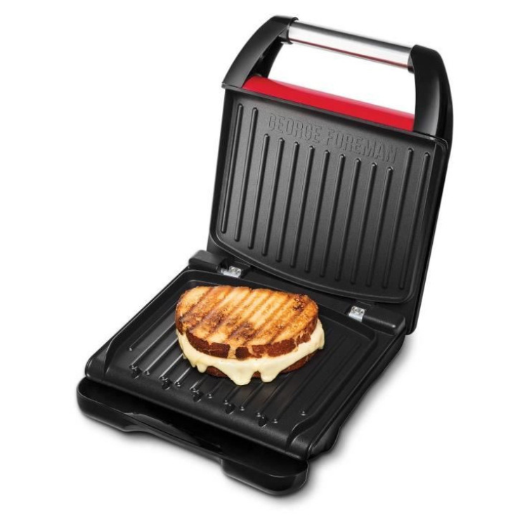 George Foreman grill with sandwich on plate, black and red, open.