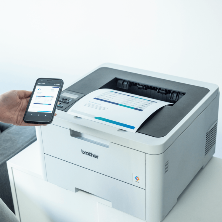 Brother HL-L3220CW color laser printer with paper output and mobile device.