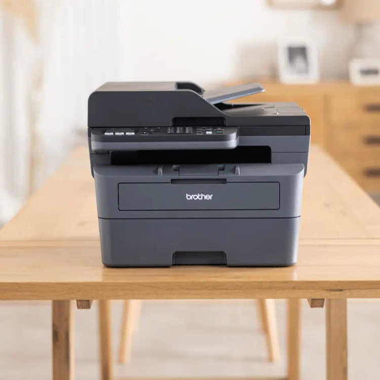 Black Brother MFC-L2800DW laser multifunction printer on a table.