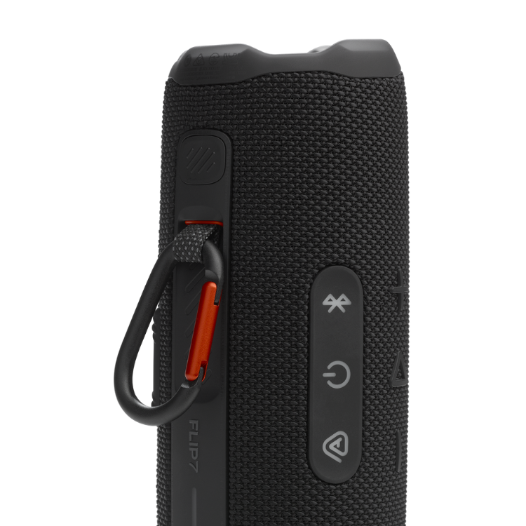 Black JBL Flip 7 portable Bluetooth speaker with textured surface, orange carabiner, and control buttons.
