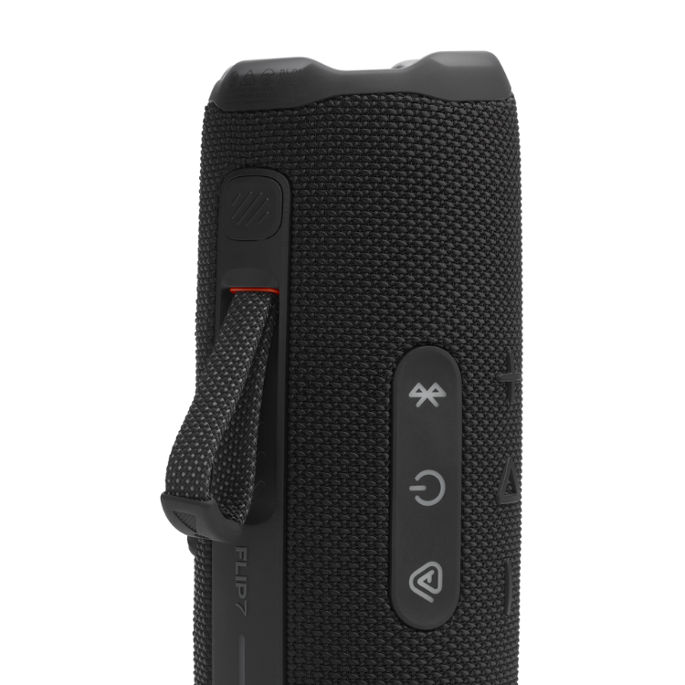 Black JBL Flip 7 portable Bluetooth speaker, close-up of side with buttons and strap.