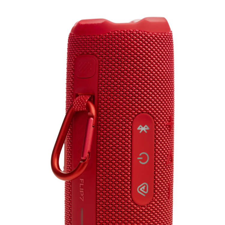Red JBL Flip 7 portable speaker with carabiner and control buttons.
