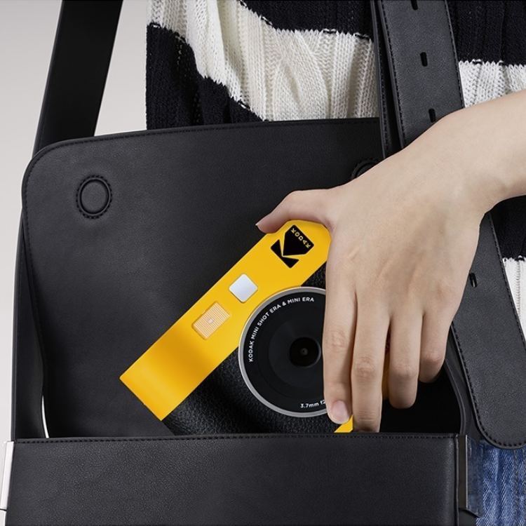 Yellow Kodak Mini Shot 3 Era instant camera being held by a hand.