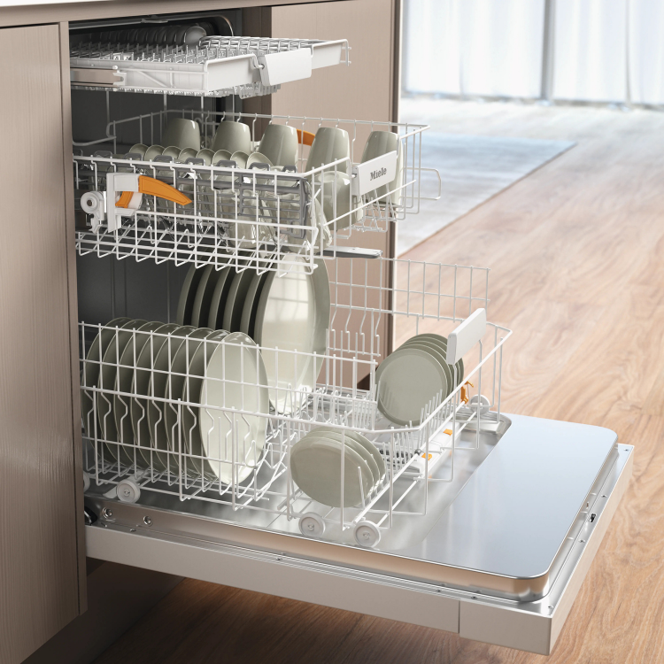 Máquina de lavar loiça Miele com 14 conjuntos, branca, cesto interior com loiça.