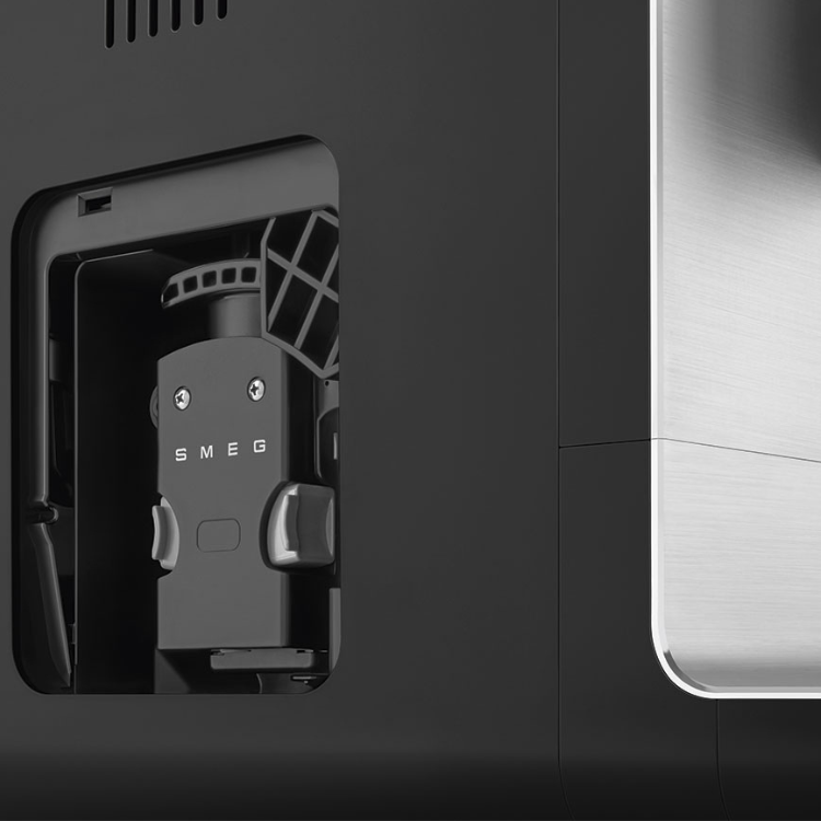 Black Smeg automatic coffee machine, close-up of SMEG logo and internal mechanism.