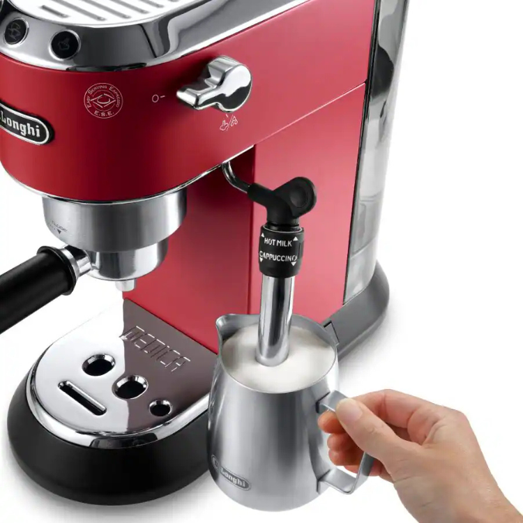 Red De'Longhi Dedica Style espresso machine with manual steam wand and stainless steel pitcher.