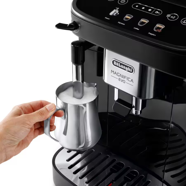 Black De'Longhi Magnifica Evo automatic coffee machine with hand holding frothy milk pitcher.