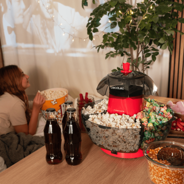 Red and black Cecotec Fun&Taste P'Corn Lotus popcorn machine on table with snacks.