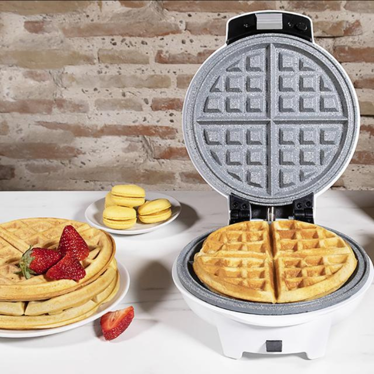 Cecotec Fun Gofrestone 3-in-1 waffle maker, white and black, with waffles and strawberries on a table.