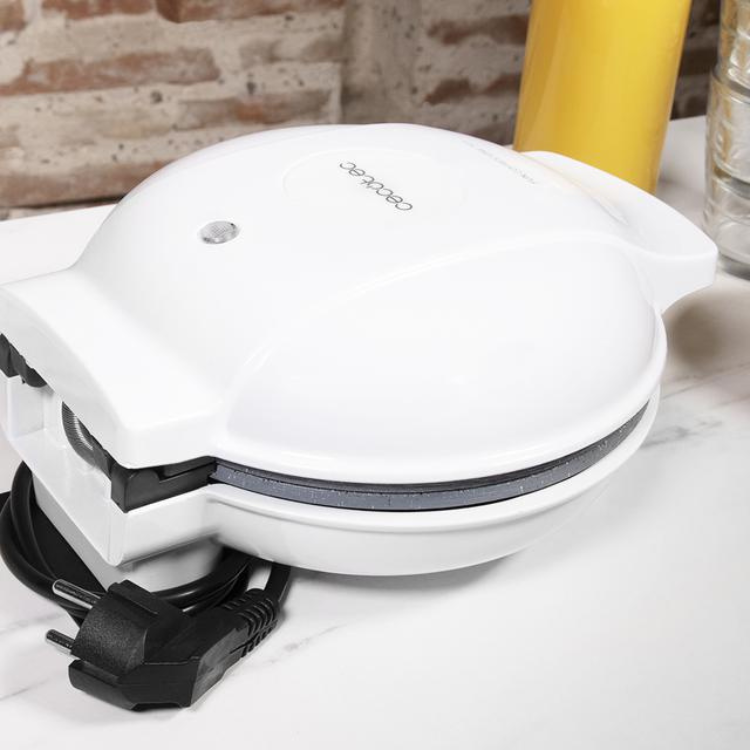 Cecotec white 3-in-1 waffle maker with black cord, on white marble countertop.