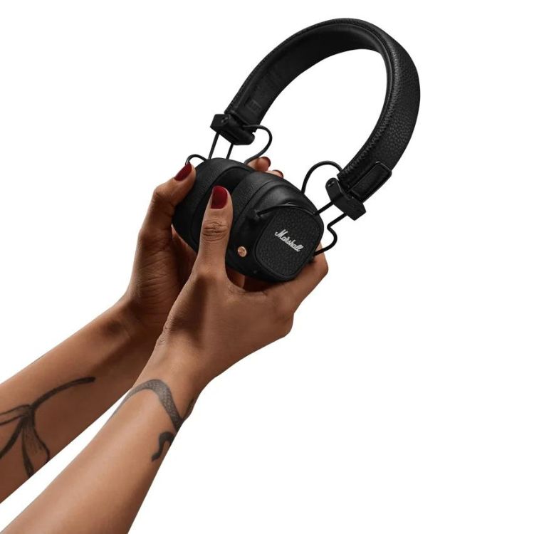 Black Marshall Major V on-ear headphones held by hands with red nails and tattoos.