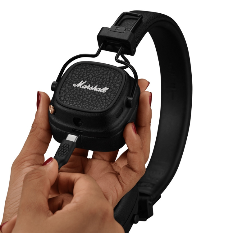 Black Marshall Major V on-ear headphones, hands holding.