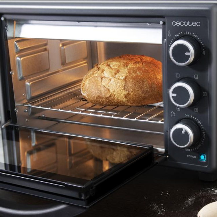 Cecotec Mini Forno Bake&Toast 2600, black oven with silver dials and loaf of bread inside.
