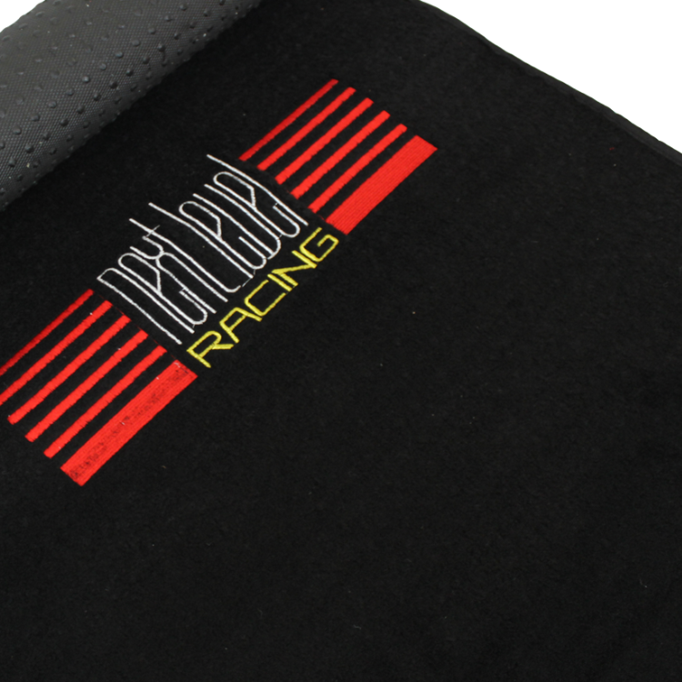 Next Level Racing floor mat, black with red and yellow logo.