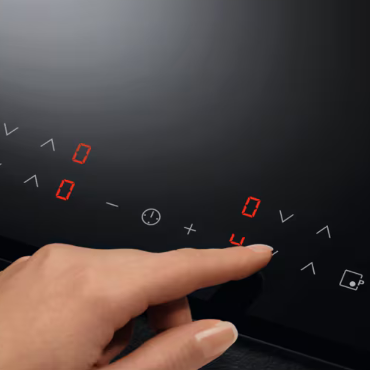 AEG induction cooktop control panel with red and white symbols, finger pressing button.