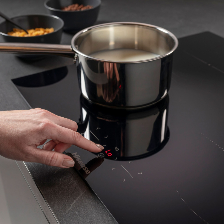 Hisense black induction cooktop with pot and control panel.