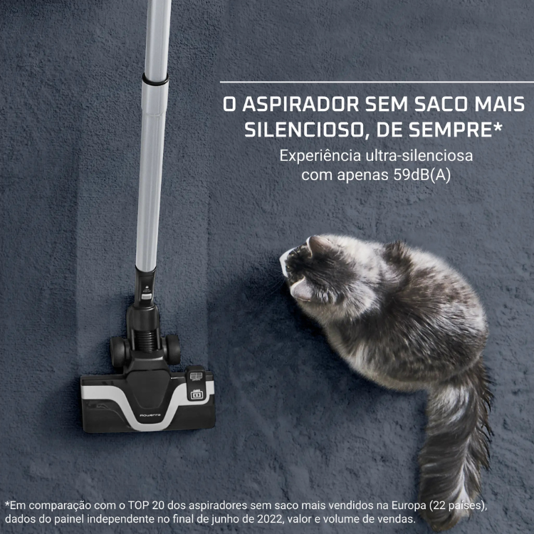 Black and white Rowenta vacuum cleaner on dark blue carpet next to gray cat.