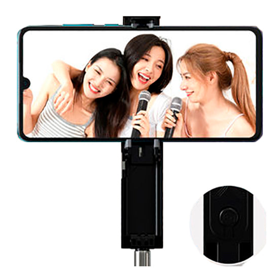 Mini haste de selfie DEVIA com conector Jack 3.5mm, preto, com telemóvel a mostrar três mulheres a tirar uma selfie.