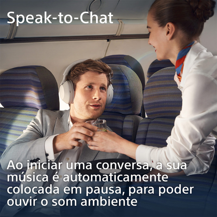 White Sony over-ear headphones on a man sitting in an airplane seat.