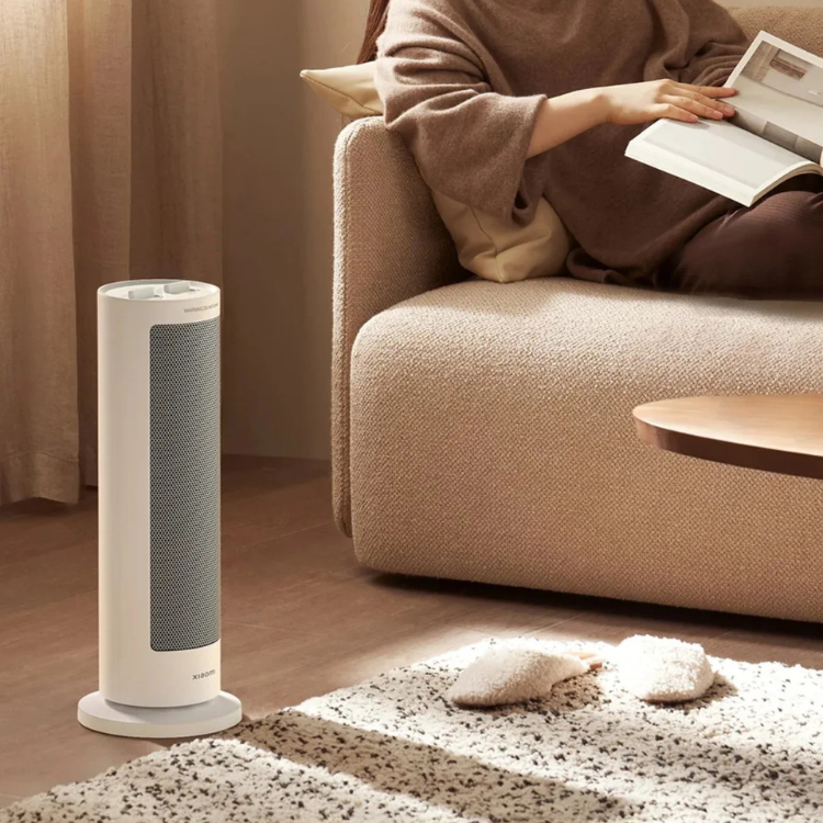 Xiaomi white electric fan heater, 2000W, standing on floor next to sofa.