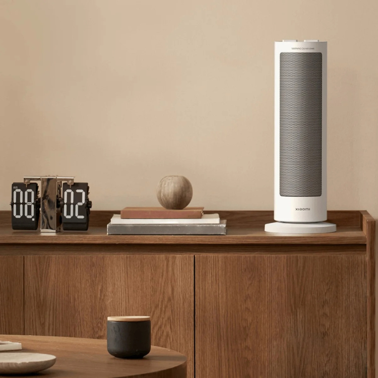 Xiaomi white electric fan heater on a wooden shelf.